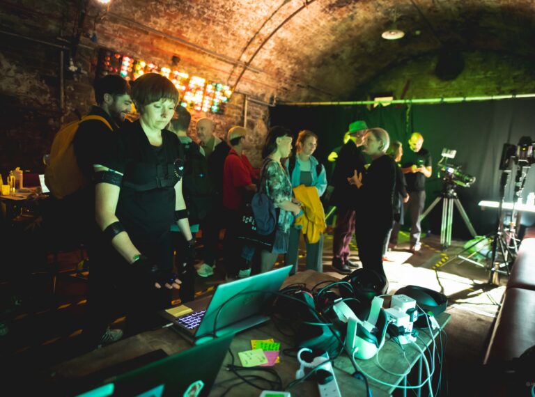 A picture of a woman surrounded by virtual reality kit.