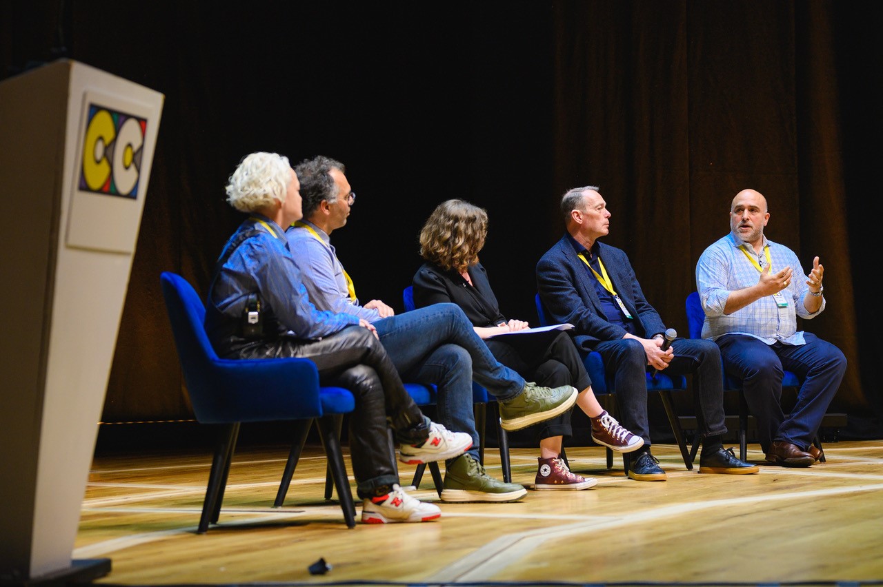 A photograph of a panel discussion.