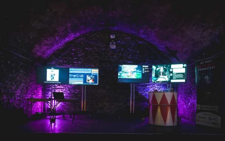 4 screens in purple lit dark space